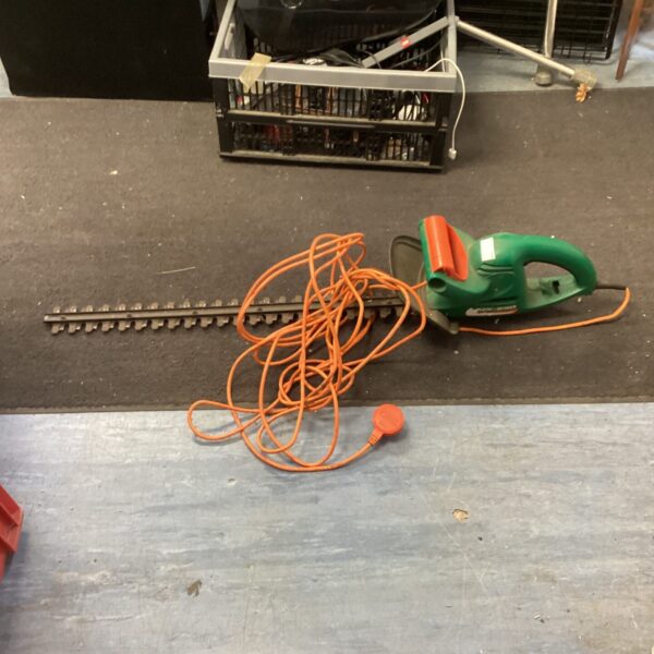 Used Black and Decker electric hedge trimmer for garden landscaping.