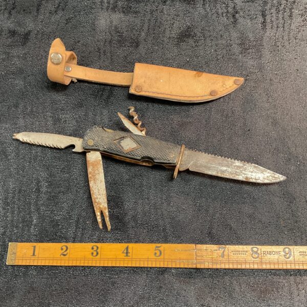 Vintage scout sheath knife with leather sheath, collectible fixed blade.