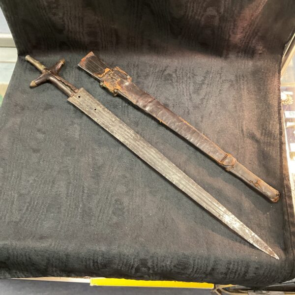 Vintage Asian sword with a curved blade and weathered handle.