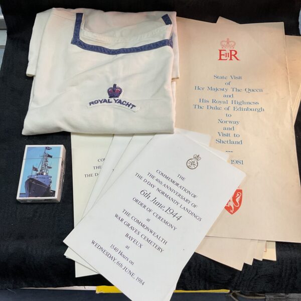 Royal Yacht Britannia memorabilia including state visit programs and sailor's tunic.