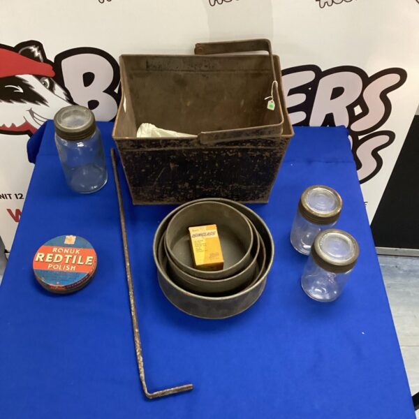 Antique jar and tin collection with flue rake on display.