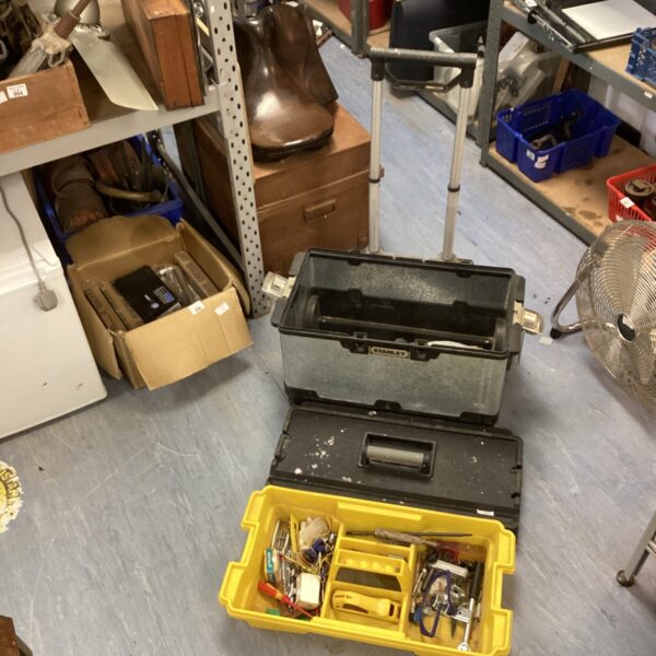 Full view of a used Stanley wheeled tool box with contents.