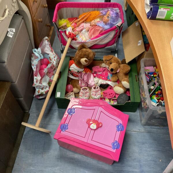 Children's toy lot with Barbie, teddy bears, and a dolls crib.
