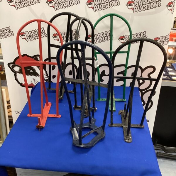 Six metal wall mounted saddle rests for equestrian storage.