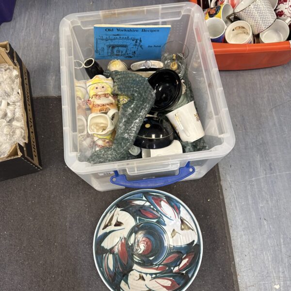 Vibrant decorative ceramic bowl in a mixed lot of collectibles.