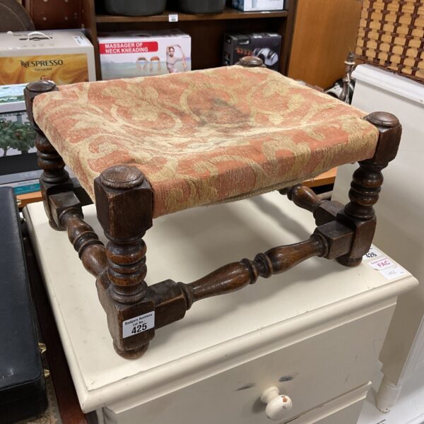 Antique fabric topped footstool with turned wooden legs.