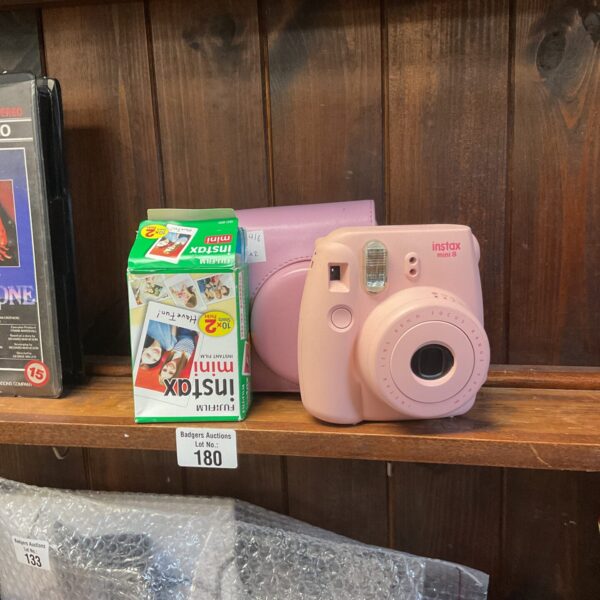 Fujifilm Instax Mini 8 camera with film, a retro instant camera.