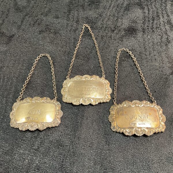 Antique silver decanter labels set, hallmarked and detailed.