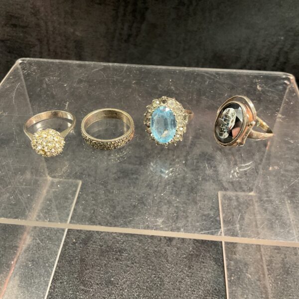Mixed lot of four 925 silver rings on a white surface.