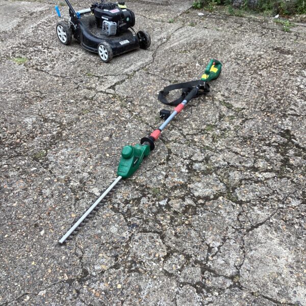 Qualcast battery pole hedge cutter in a garden setting.