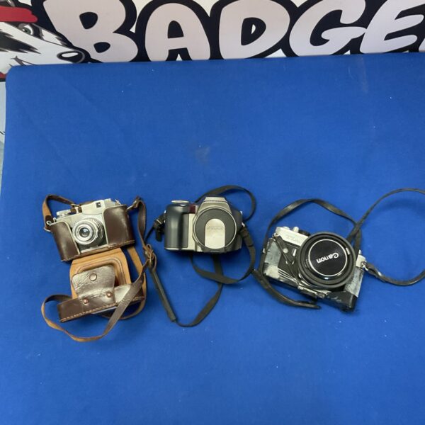 Vintage camera lot featuring Canon, Olympus, and Comet cameras.