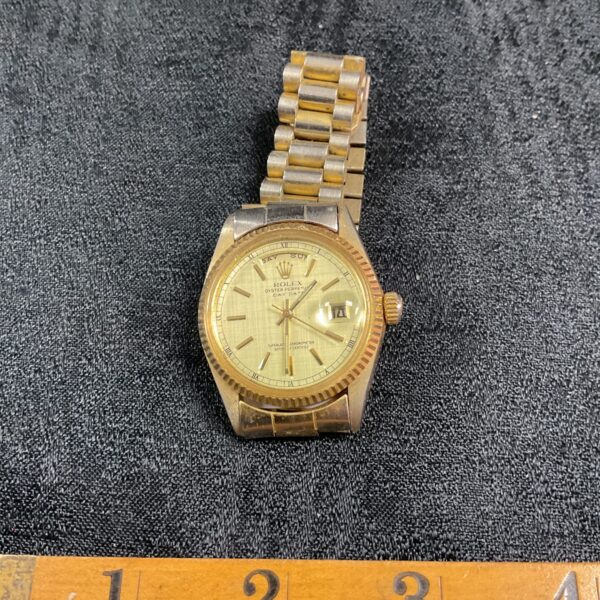 Gold-tone reproduction Rolex Day-Date wristwatch on display.