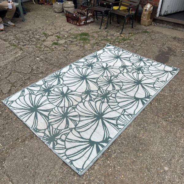 Patterned plastic outdoor rug for garden or camping use.