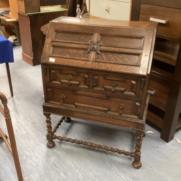 Antique oak bureau with drawers and sloping writing surface.