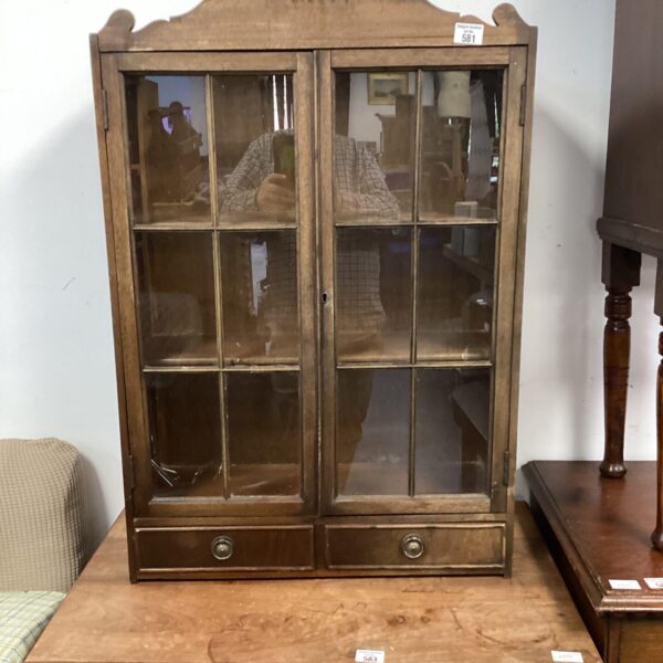 Vintage wooden display cabinet with glass front for collectibles.