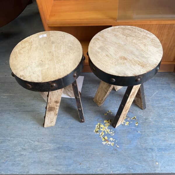 Pair of rustic wooden stools with three legs.