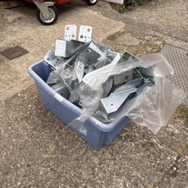 Assorted galvanized steel joist brackets in a plastic storage box.