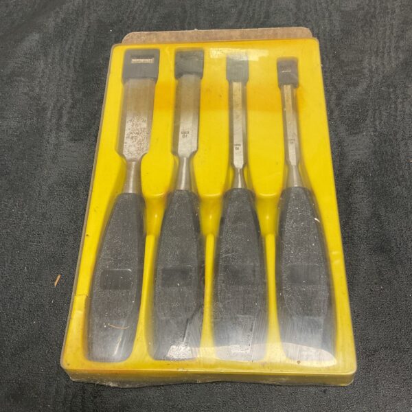 Vintage set of four wood chisels with wooden handles.