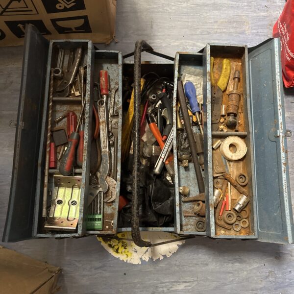 Open vintage cantilever toolbox filled with various tools.