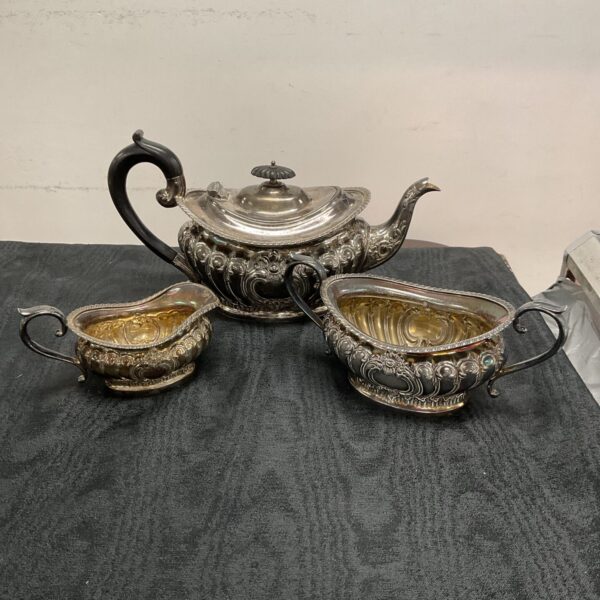Antique silver tea set by Thomas Otley, featuring teapot, sugar, and creamer.
