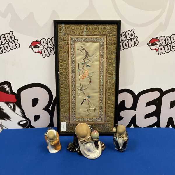 Vintage Chinese mud men figurines and silk embroidery displayed on blue surface.
