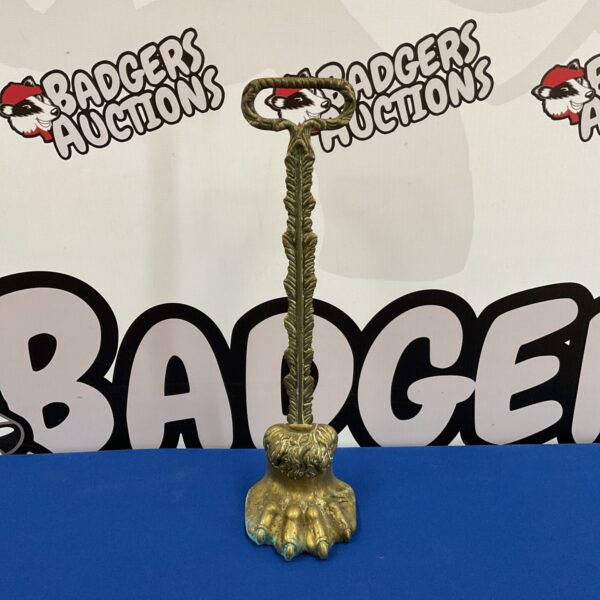 Antique Victorian brass lion doorstop with detailed paw.