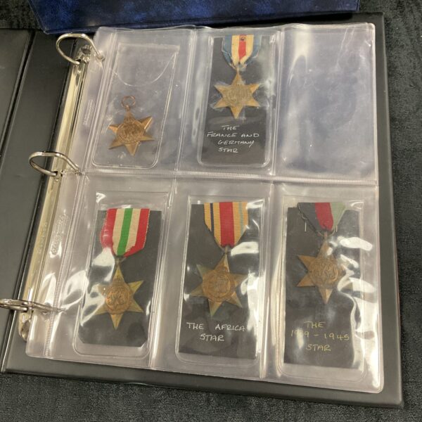 Front view of WWII medal storage album with medals visible.