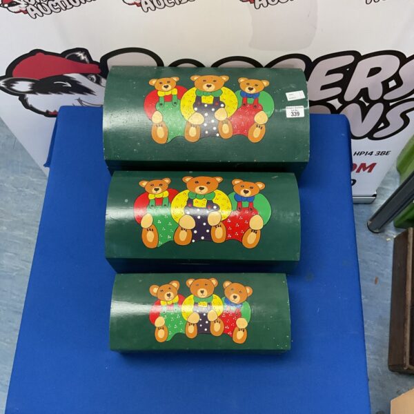 Vintage wooden toy chests with three bears design for nursery storage.