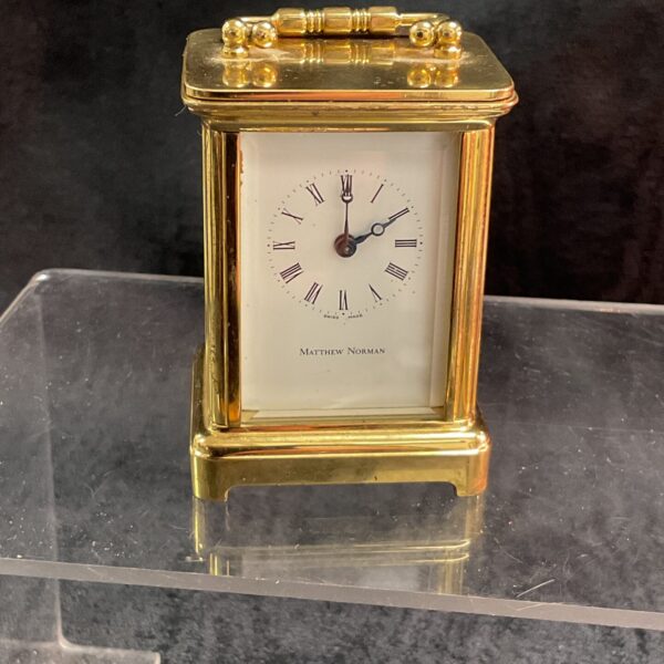 Front view of a vintage Matthew Norman brass carriage clock.
