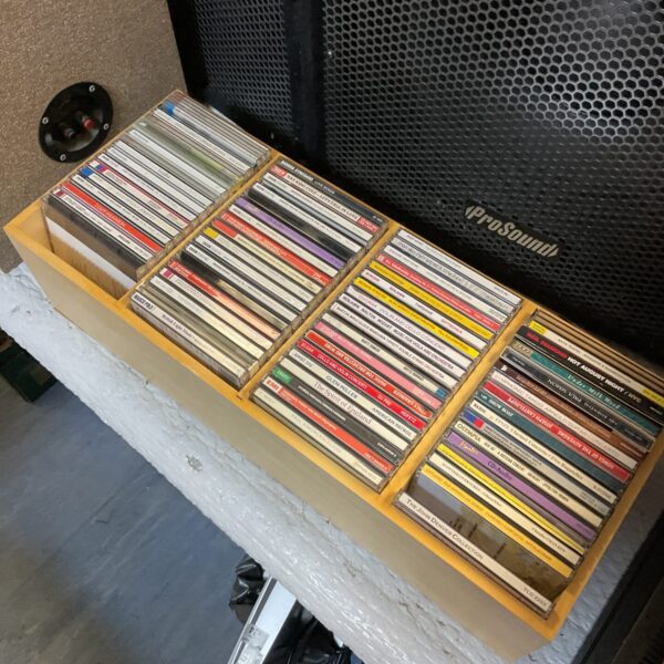 Vintage wooden tray filled with a diverse CD collection.