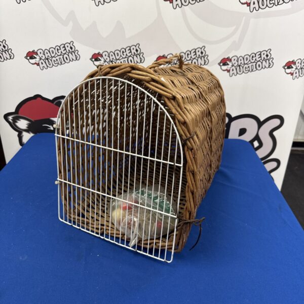 Vintage wicker cat carrier with toys inside.