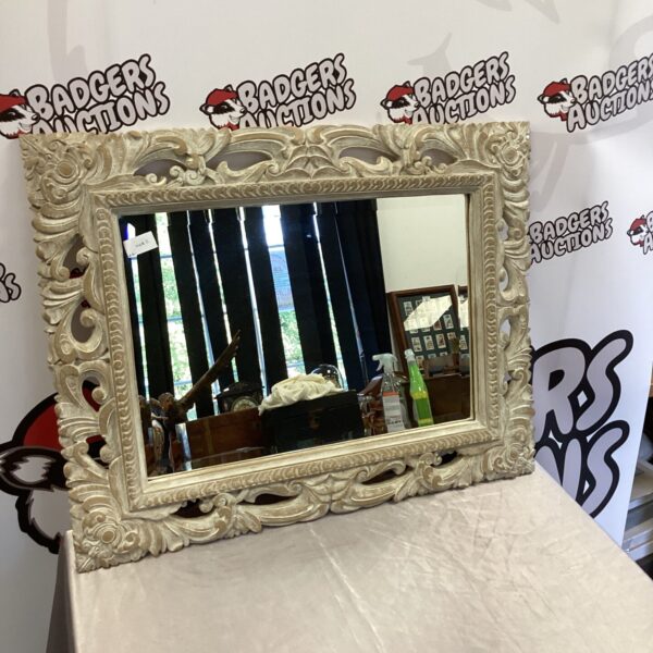 Ornate wood framed mirror with detailed carvings for home decor.