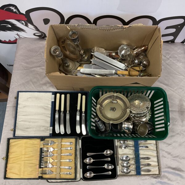 Vintage silver plate cutlery and candlestick collection on display.