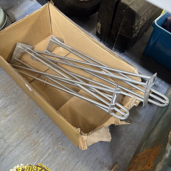 Metal saddle racks inside a cardboard box, equestrian storage solution.