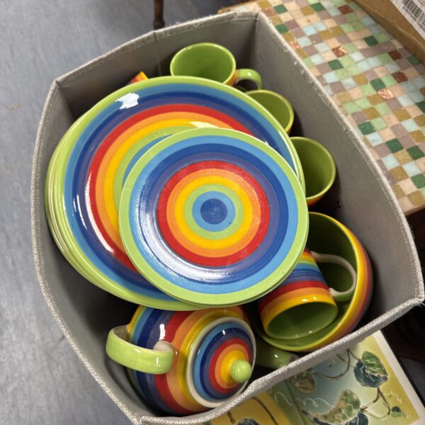 Colourful Lovewindhorse dinner service plates and jug on display.