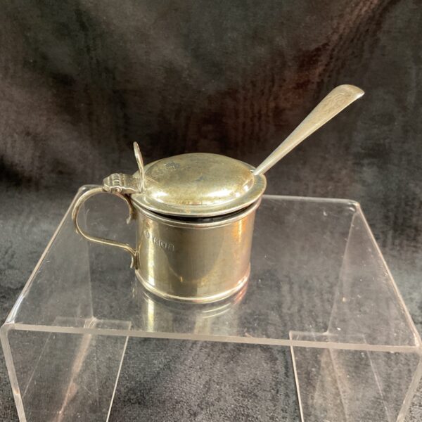 Antique silver mustard pot with spoon and blue liner.