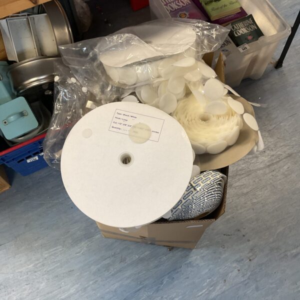 Large assortment of assorted velcro stickers and strips in a box.