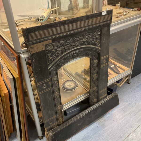 Intricate Victorian cast iron fire surround for antique fireplace restoration.