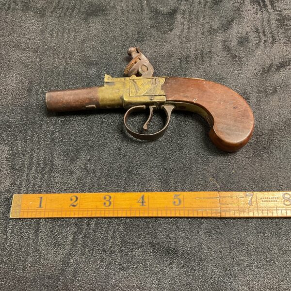 Antique flintlock pistol by Baker London, detailed view.