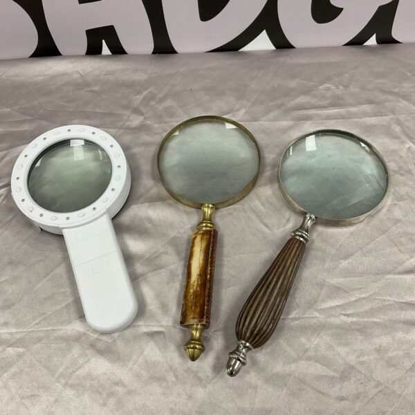 Lot of three vintage magnifying glasses with wooden handles.