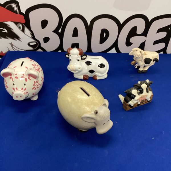 Ceramic piggy banks and cow figurines in a collectible lot.