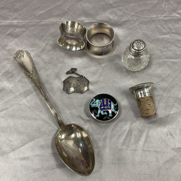 Antique silver and white metal collectibles including pill pot and bottle stopper.