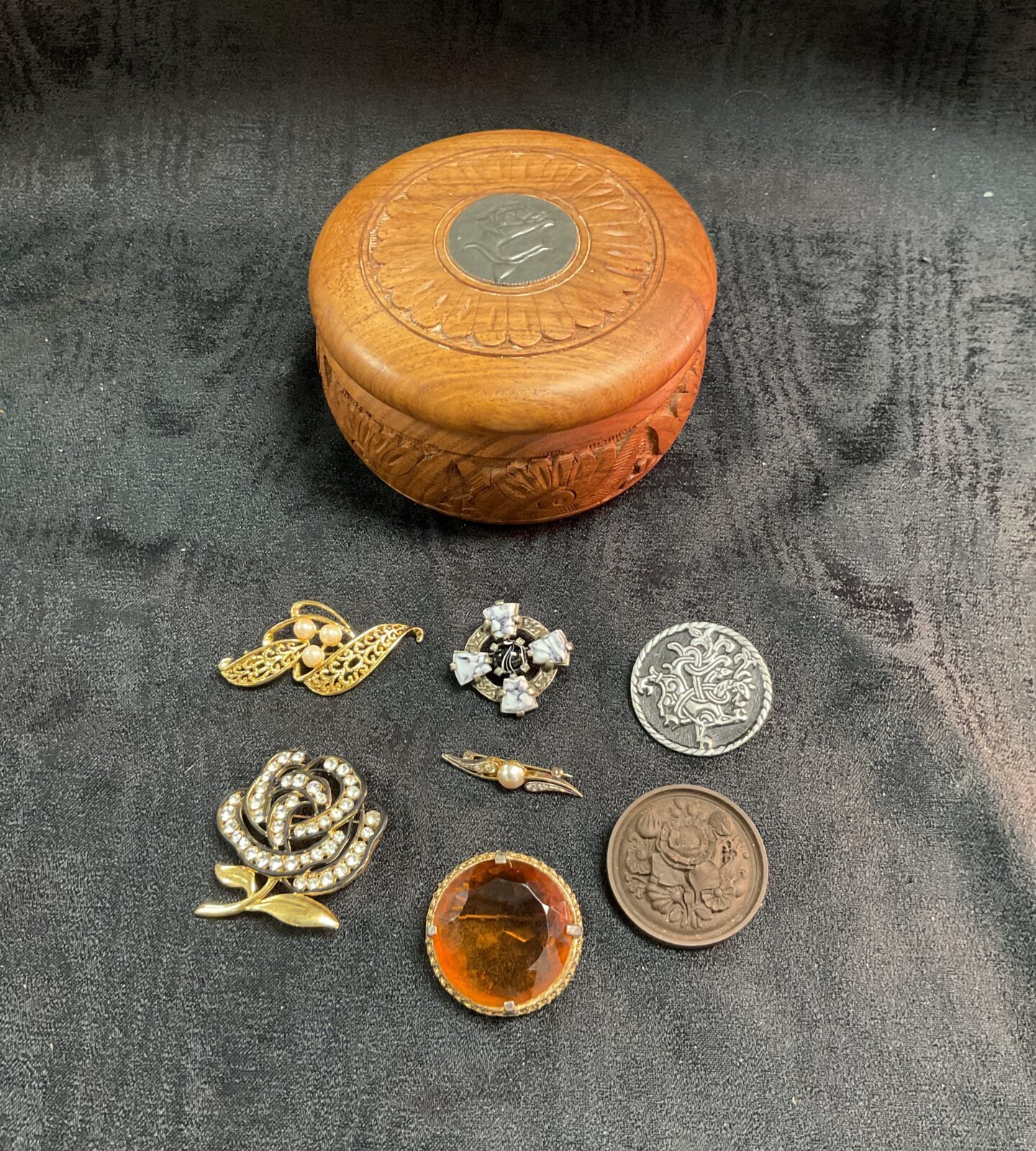 Wooden trinket box with a collection of brooches inc Scottish pewter and ceramic