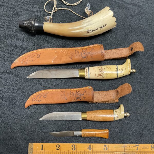 Vintage Norwegian knives with intricately carved horn sheaths.