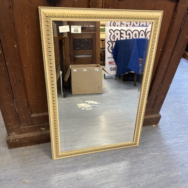 Vintage bevelled glass mirror with ornate frame.