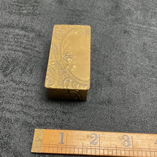 Intricate Art Nouveau brass stamp box with floral carvings.