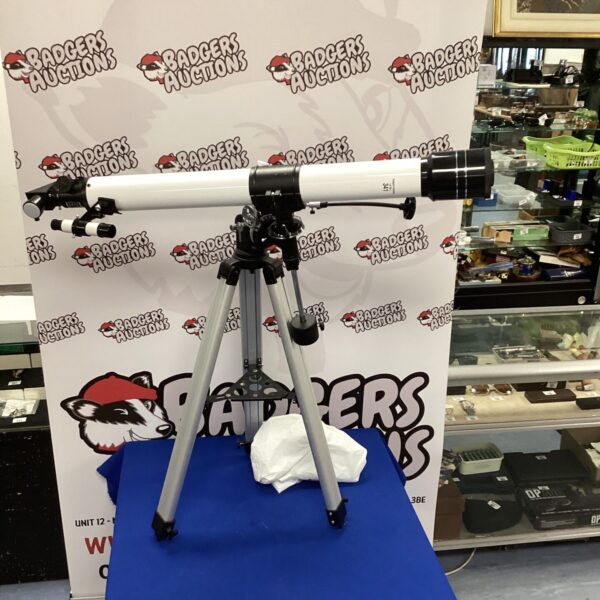 Vintage refractor telescope with tripod stand for stargazing.
