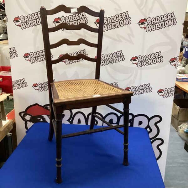 Vintage rattan hall chair with woven seat and wooden frame.