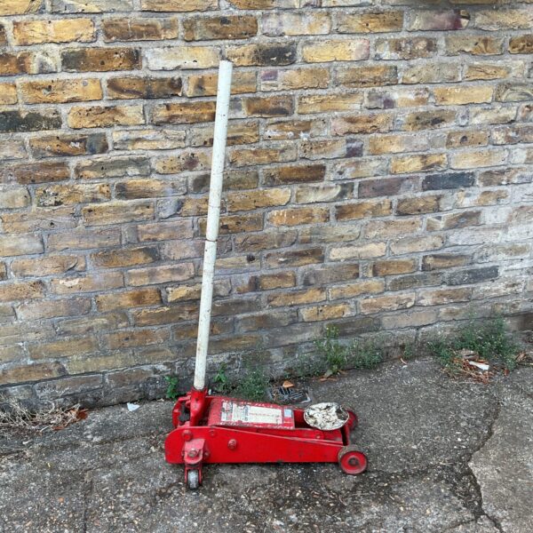 Red Sealy 2 ton trolley jack for automotive repairs.