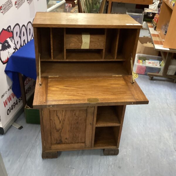 Antique oak writing bureau with storage compartments.